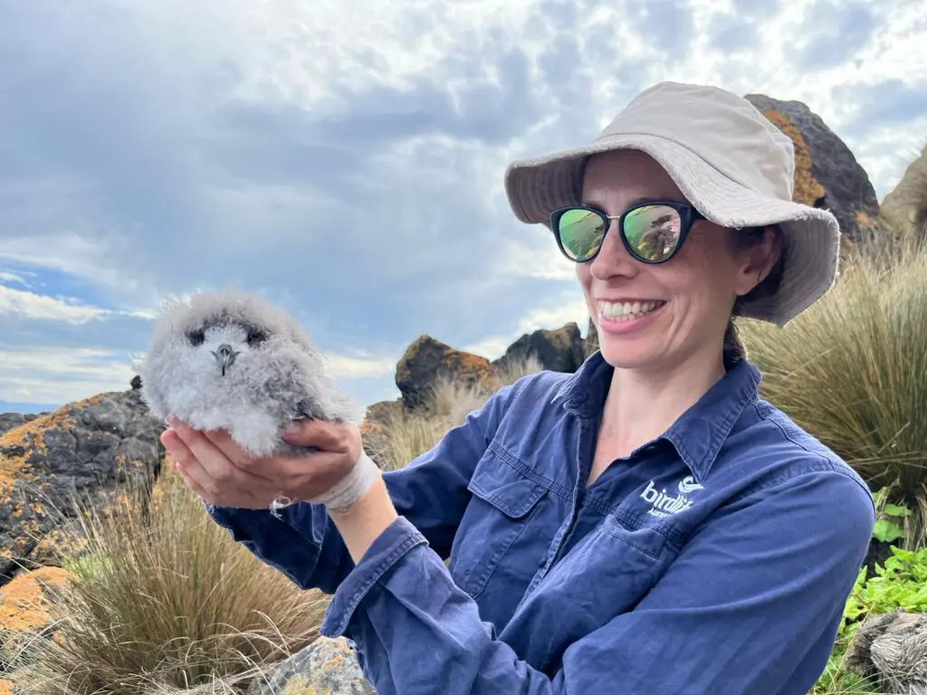 Woman holding a seabird chick for research