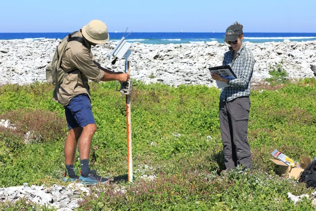 Two people standing on grass on an island doing research