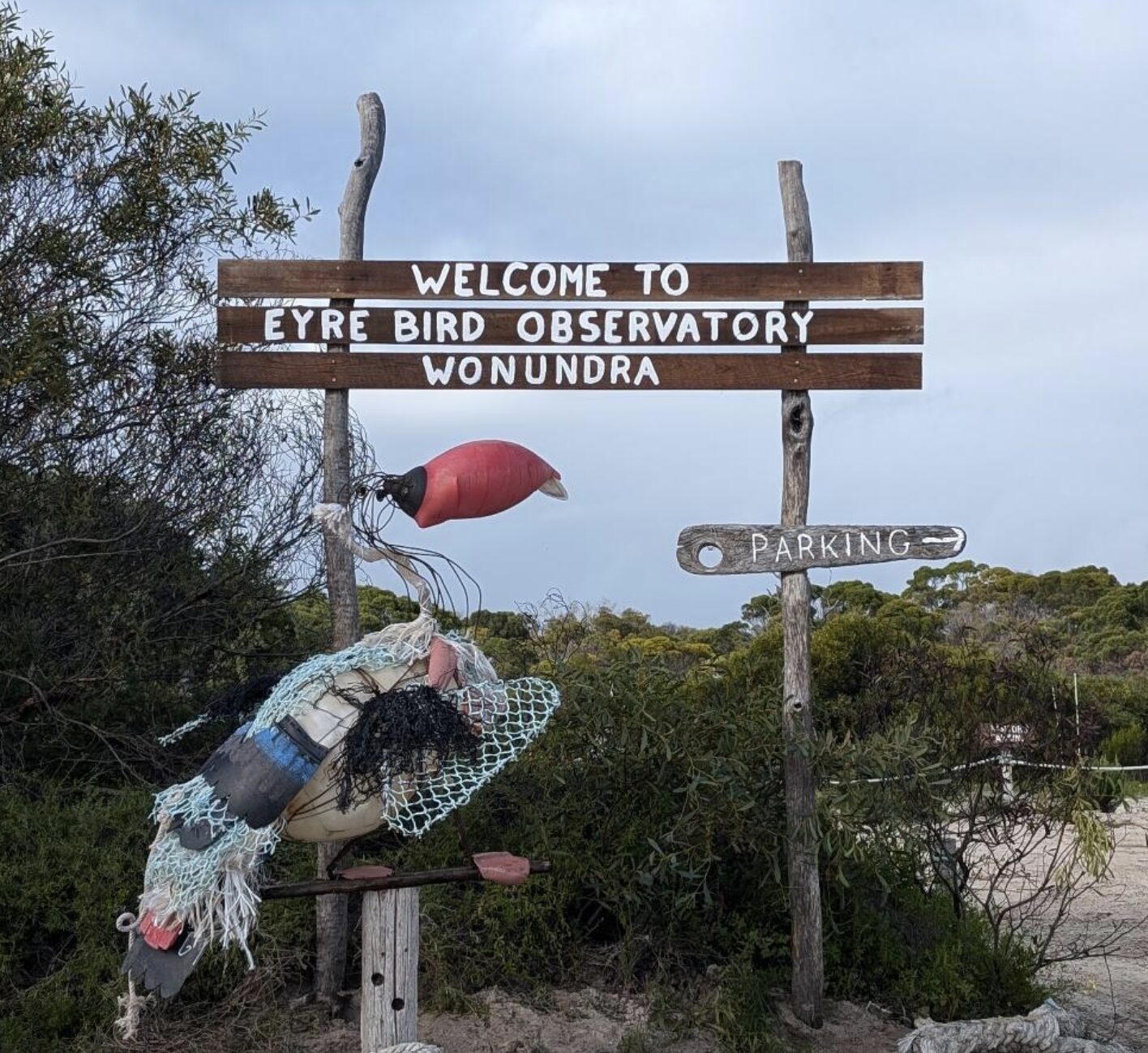 Hand-painted signage at the entrance of the Eyre Bird Observatory. The signs read: Welcome to Eyre Bird Observatory Wonundra, with an arrow pointing towards parking.