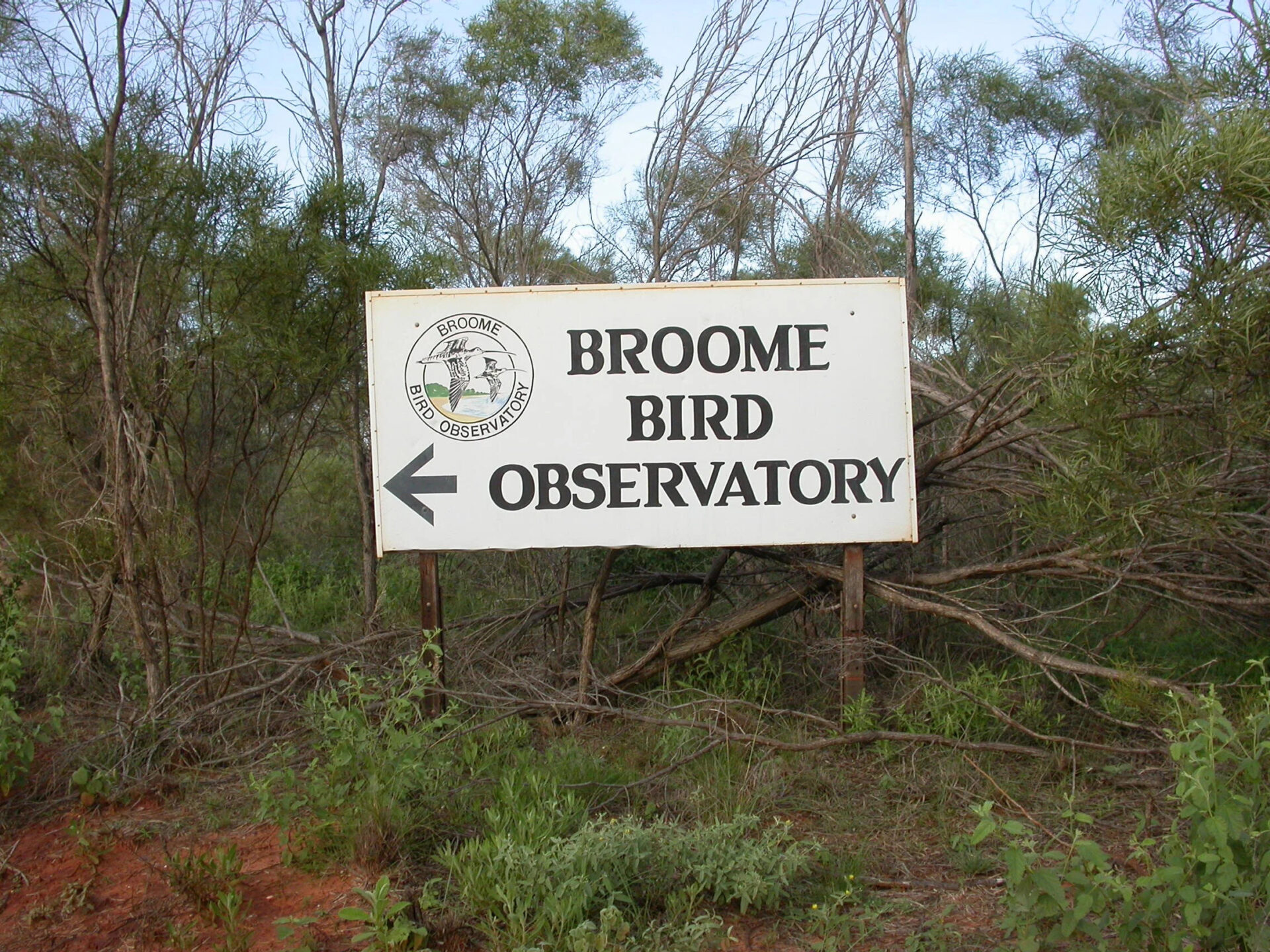 A sign in woodland that reads Broome Bird Observatory, with the BBO logo.